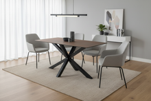 Load image into Gallery viewer, Dining room with a wooden table and gray chairs on a beige rug.