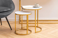 Load image into Gallery viewer, Gold side table with marble top next to a gray chair on a wooden floor.