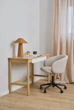 Load image into Gallery viewer, A light wood writing desk with a white drawer front and a beige upholstered swivel chair, styled in a bright room with a wicker lamp, curtains, and a light wood floor.