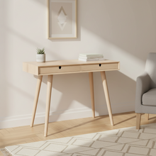 Load image into Gallery viewer, A light natural wood writing desk with two drawers and tapered legs, styled in a minimalist room setting with a small potted plant and books on top.