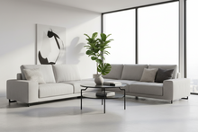 Load image into Gallery viewer, Modern living room with a gray sectional sofa, coffee table, and decorative items.