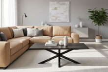 Load image into Gallery viewer, Modern living room with beige sectional sofa, black coffee table, and decorative elements.