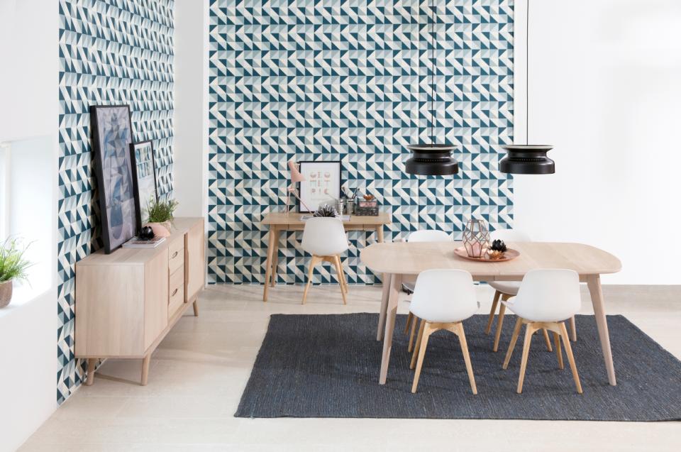 Modern living room with a dining table, chairs, and decorative wall patterns.