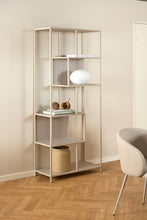 Load image into Gallery viewer, Modern metal bookshelf with decorative items against a beige wall.