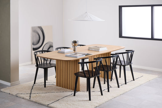 A Corby dining table with 6 black Ida chairs