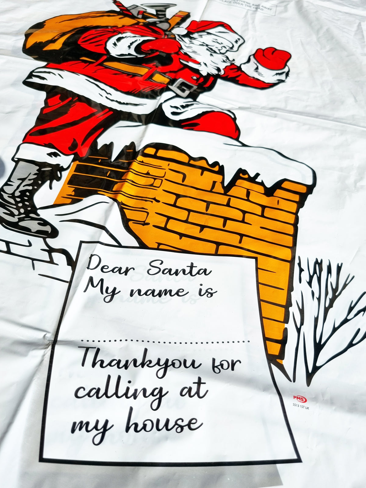 A white Christmas-themed plastic bag featuring a large illustration of Santa Claus climbing a chimney and a printed note that reads, 'Dear Santa My name is Thank you for calling at my house'.