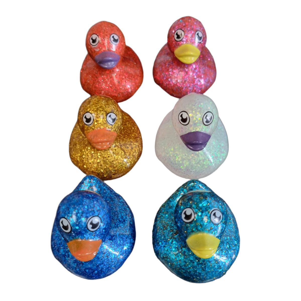 Colorful glitter ducks on a white surface
