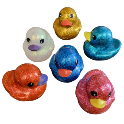 Set of colorful glittery rubber duck toys on a white background
