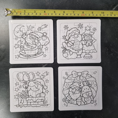 Four uncompleted black and white Christmas-themed jigsaw puzzles arranged in a 2x2 grid on a dark surface, with a yellow tape measure above them for scale.
