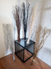 Load image into Gallery viewer, Decorative branches on a black metal table against a white brick wall.
