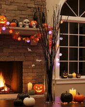 Load image into Gallery viewer, Halloween-themed room with pumpkins, candles, and decorative lights.
