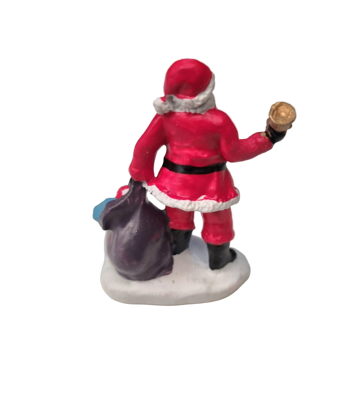 A small Santa Claus figurine shown from the back, wearing a red suit with white trim, black belt and boots, standing on a white base and holding a dark sack and a gold coin against a plain white background.