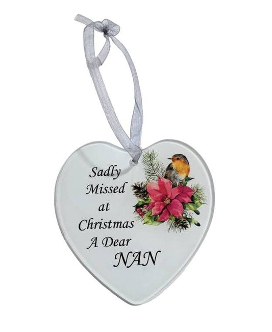 a glass heart with ribbon attached with an image of a robin and a memorial message that reads 'sadly missed at Christmas a dear NAN' all on a white background.