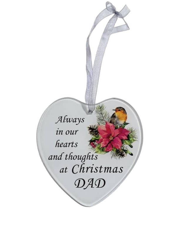 A white heart-shaped glass hanging decoration with a poinsettia flower and a robin, and the text 'Always in our hearts and thoughts at Christmas Dad'.
