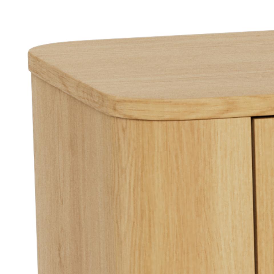 Close-up of a light natural wood sideboard corner showing the rounded top edge and wood grain texture against a white background.