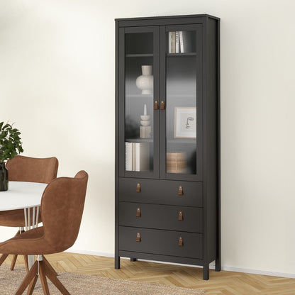 A tall Barcelona black glass-front cabinet with three upper doors and three lower drawers, styled in a dining room next to a table and chairs.