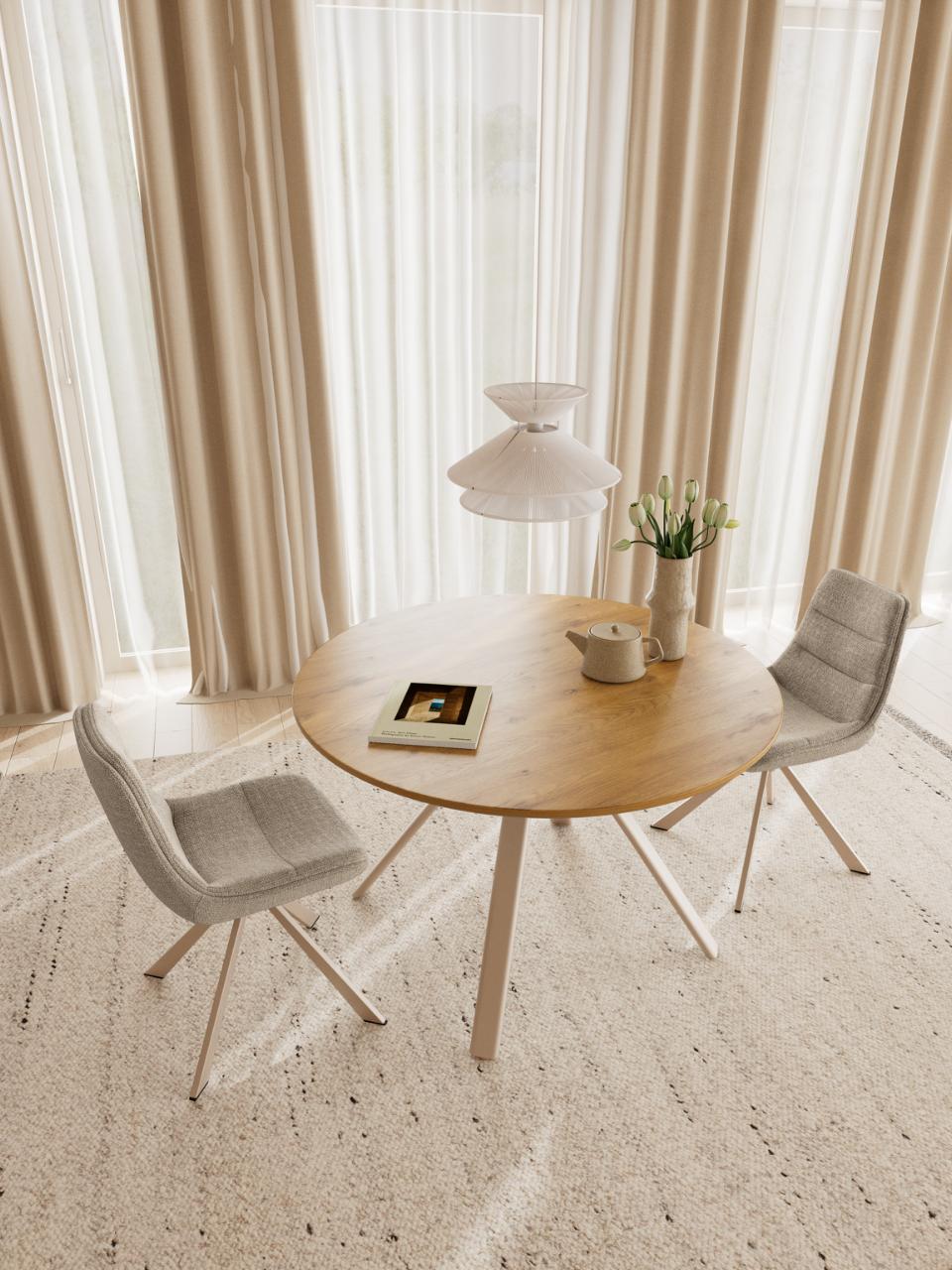 A round light wood dining table with three light gray upholstered swivel chairs in a bright, modern room with beige curtains and sheer white window drapes.