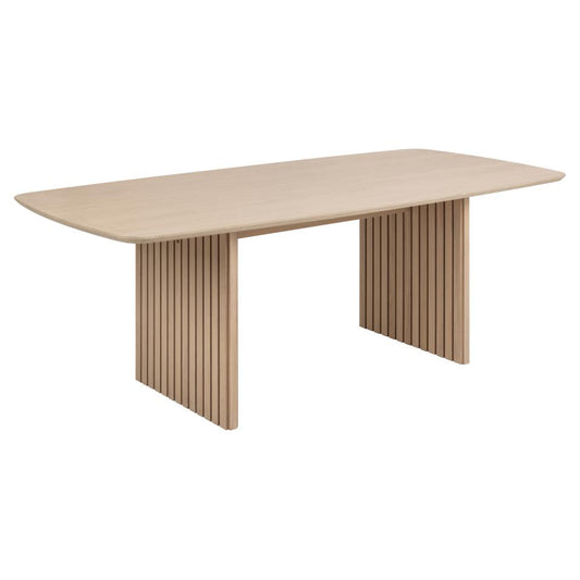 Beige dining table with unique leg design on a white background