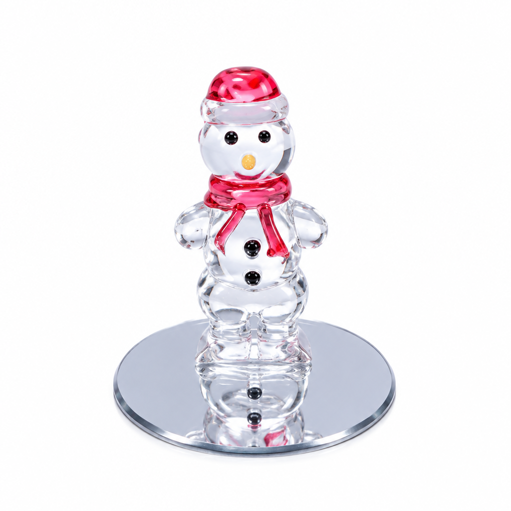 A clear glass snowman figurine wearing a red hat and red scarf, standing on a round mirrored base against a white background.