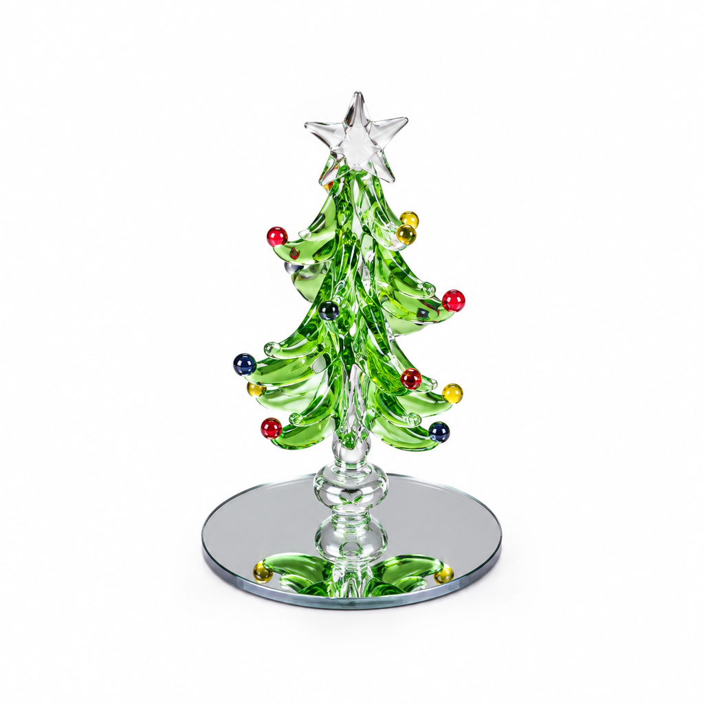 A green glass Christmas tree figurine with a silver star on top, decorated with colorful glass ornaments, standing on a round mirrored base against a white background.