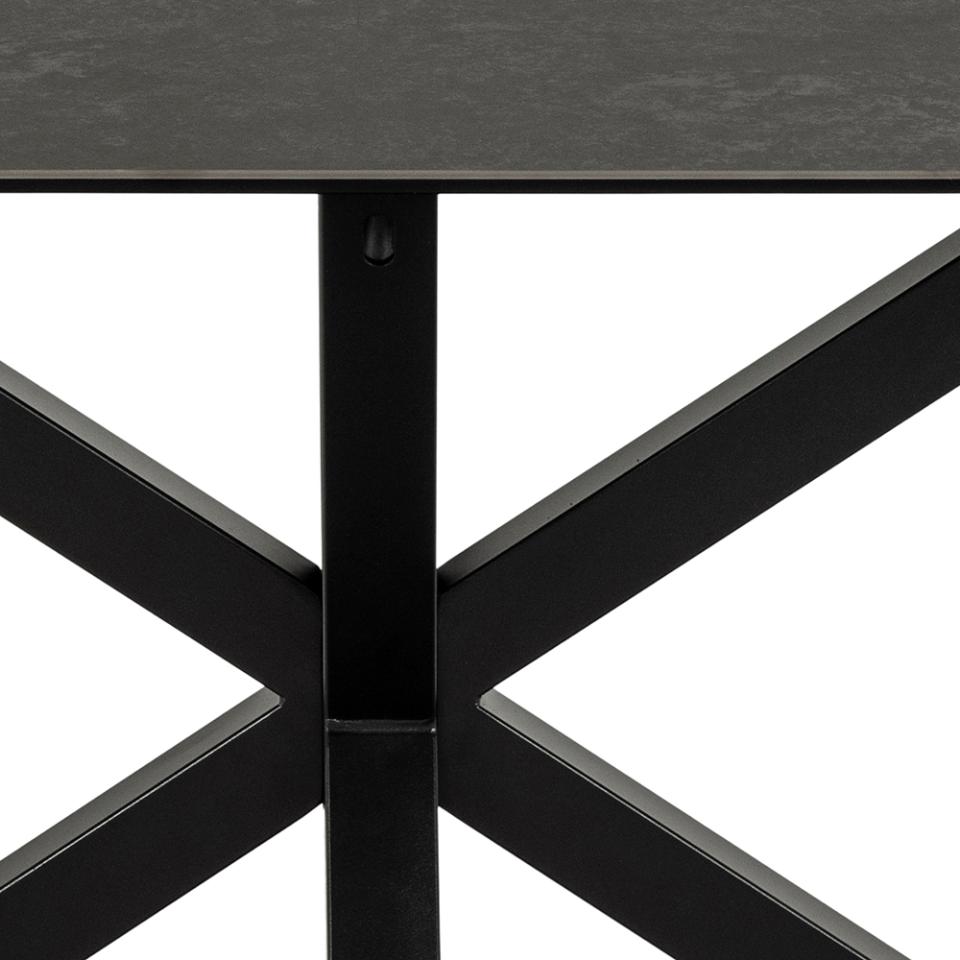 Close-up of a black metal table base with a white background