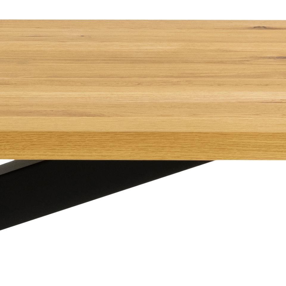 Close-up of a light oak wood tabletop with a black metal support leg visible against a white background.