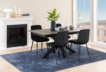 Load image into Gallery viewer, A modern dining set featuring a rectangular black ceramic table and four black chairs, styled on a blue rug in a bright room with a fireplace and large windows.
