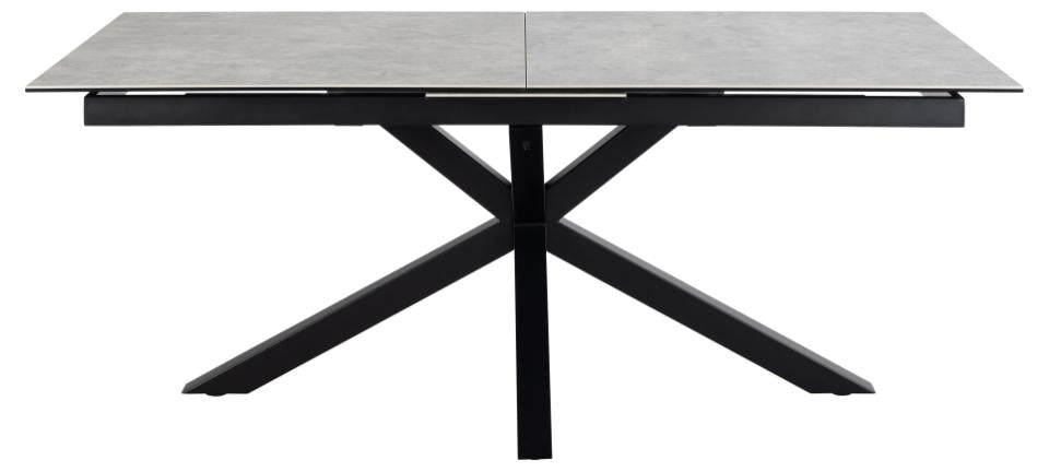 Dining table with a ceramic top and black metal legs on a white background
