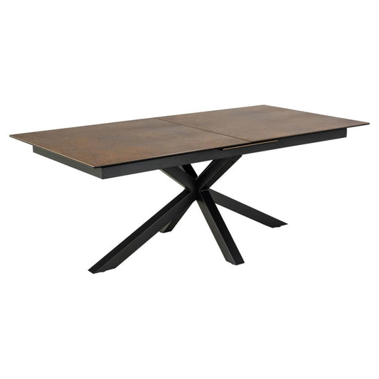 A rectangular ceramic dining table with a brown top and black metal cross base, designed to extend.