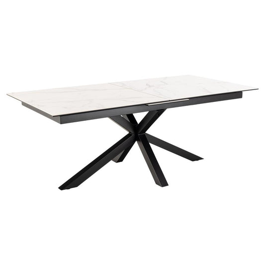 A modern rectangular dining table with a white ceramic top and a black metal cross base with the capability to extend.