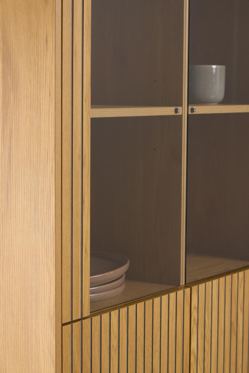 Wooden cabinet with glass doors displaying ceramic bowls.