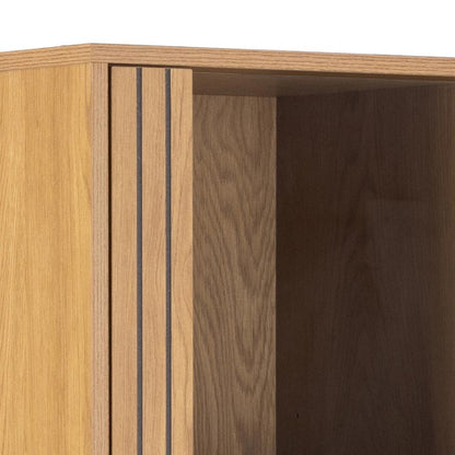 Close-up of a wooden cabinet with a light oak exterior door featuring lamella wood strip front and a darker brown wood interior.