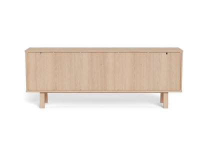 Rear view of a modern long sideboard in light natural oak wood, featuring tapered legs, shown against a plain white background.