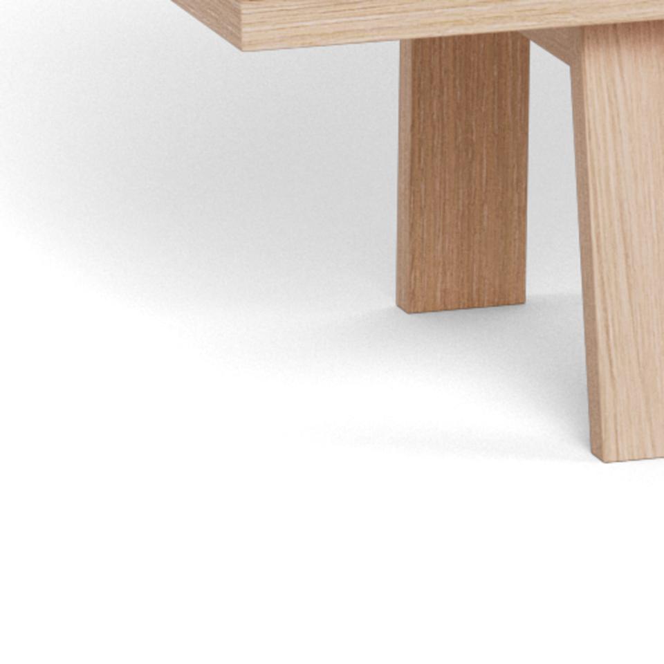 Close-up of a light natural wood sideboard leg and part of the sideboard on a clean white background.