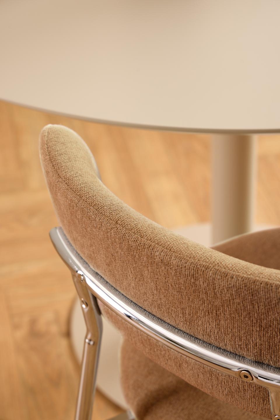 Close-up of a brown chair with a metal frame on a wooden floor.