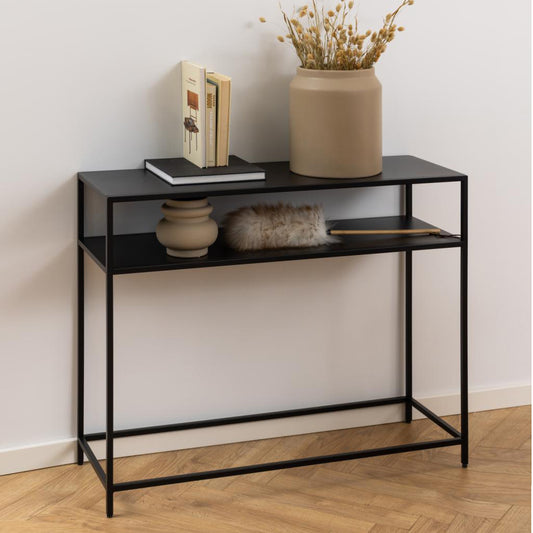 Black console table with decorative items against a white wall