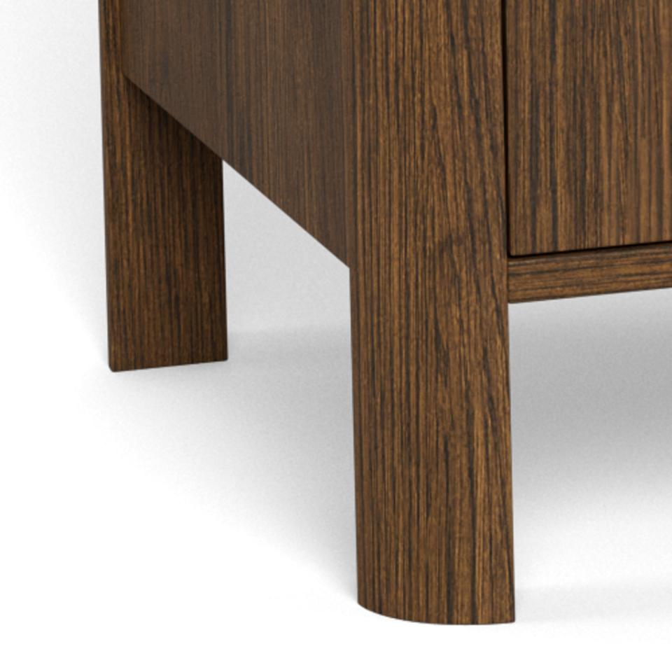 Close-up of a dark brown wood furniture piece showing a cylindrical leg and part of a sideboard door with visible wood grain texture.