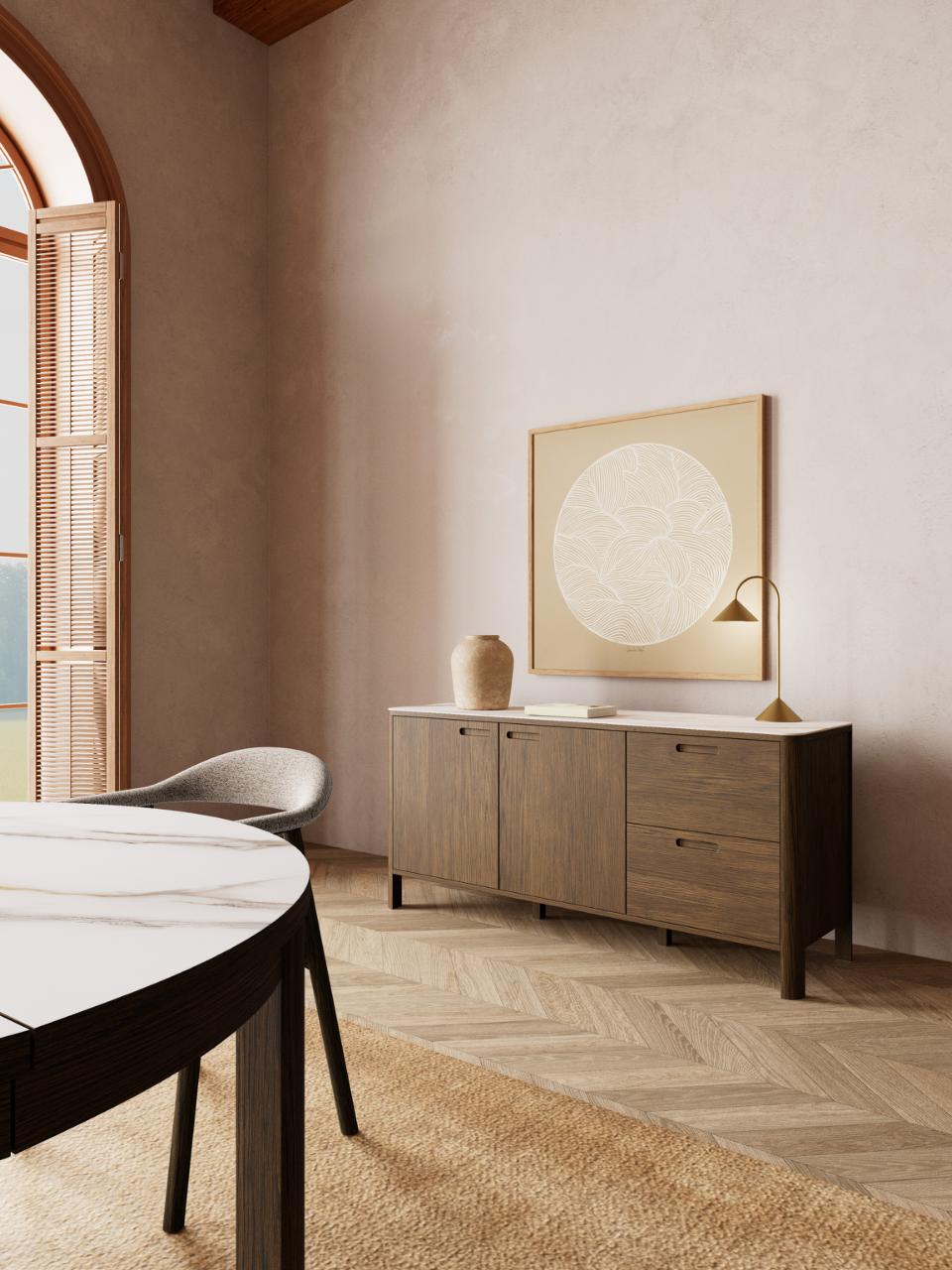 Modern dining room with wooden sideboard, round picture on the wall, and decor items.