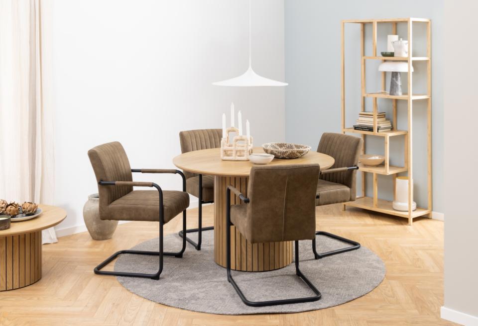 Dining area with round table and chairs in a modern interior setting.