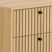 Load image into Gallery viewer, Close-up of a light oak wood cabinet with vertical slat panel doors and round black knobs.

