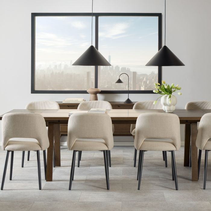 Modern dining room with wooden table and beige chairs, large window in the background.