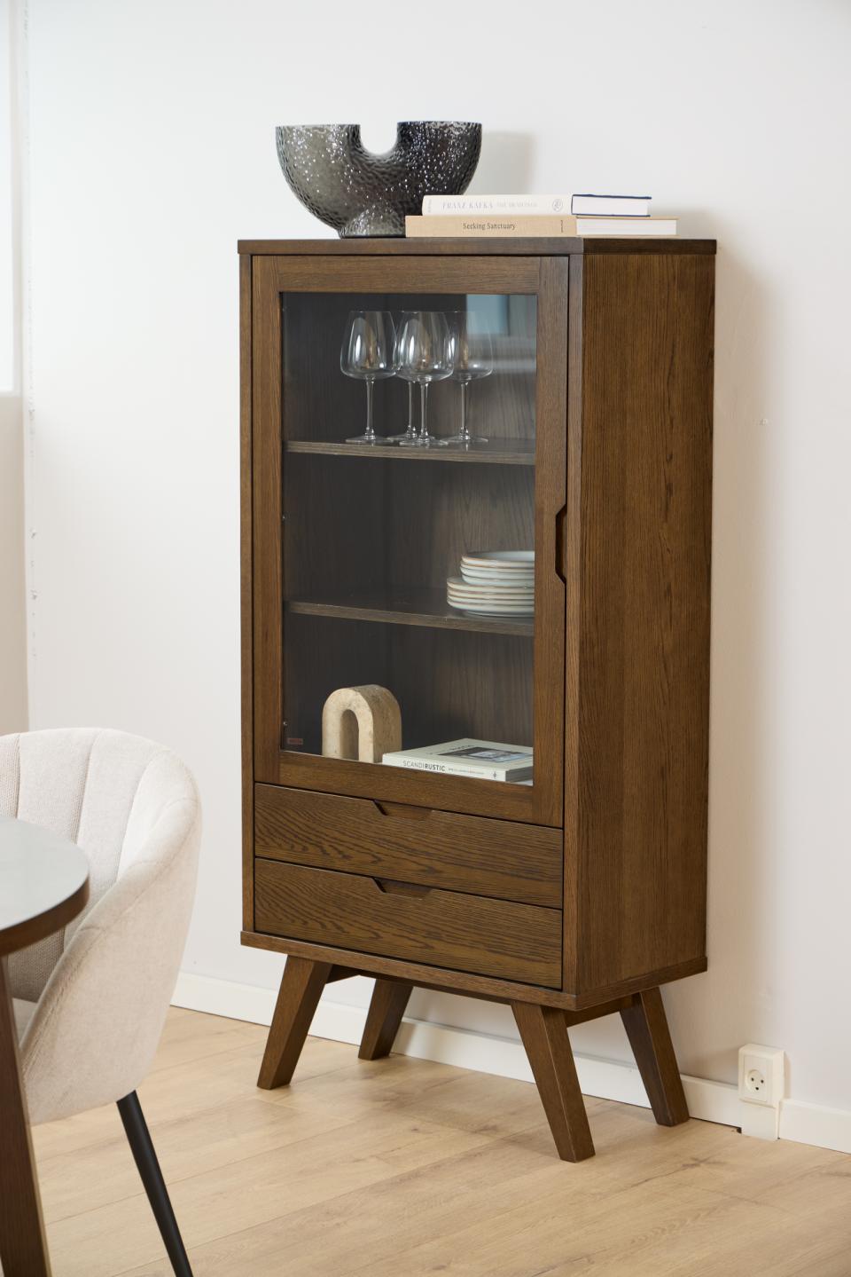 Wooden cabinet with glass door and shelves against a white wall.