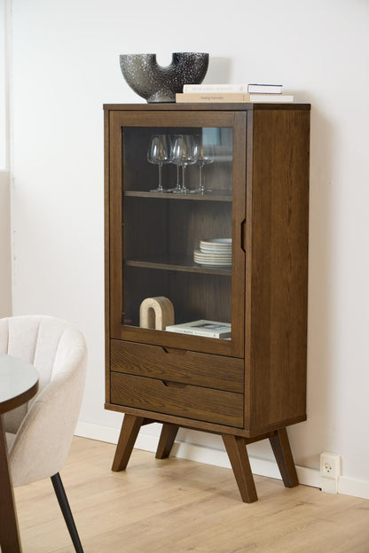 Wooden cabinet with glass door and shelves against a white wall.