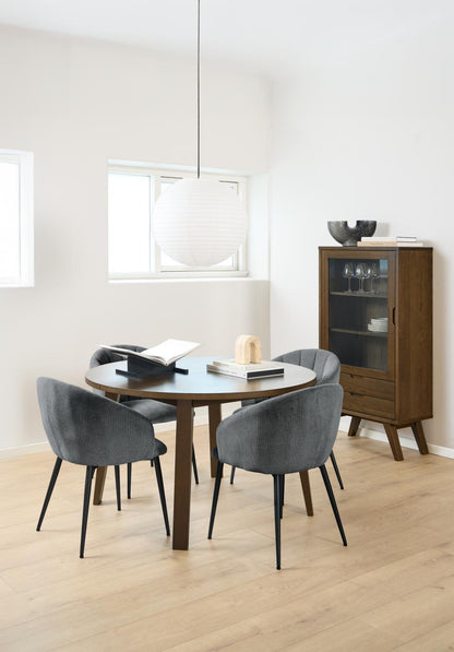 Dining area with round wooden table and gray chairs in a modern interior with an A-Line dark oak cabinet in the background