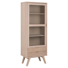 Load image into Gallery viewer, A tall, narrow light oak wood bookcase with a glass-front upper cabinet, three shelves, two lower drawers, and angled legs, shown on a solid white background.
