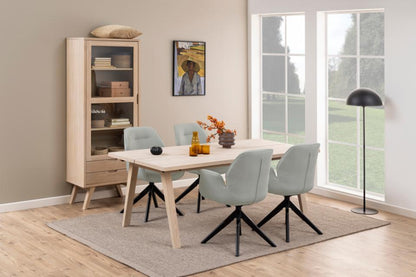 Dining room with wooden table and chairs near a large window.