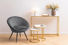Load image into Gallery viewer, Gray chair and small tables in a minimalistic room with a vase of flowers on a table.

