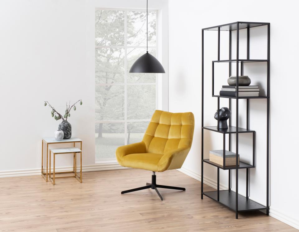 Modern living room with a yellow armchair, black shelving unit, and a window.