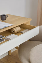 Load image into Gallery viewer, Wooden coffee table with books and a mug, next to a chair.
