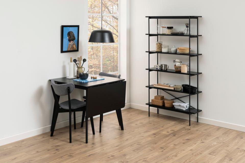 Modern home office with a black desk, chair, and bookshelf.